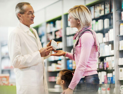 Pharmacist giving medication to a mother with her daughter