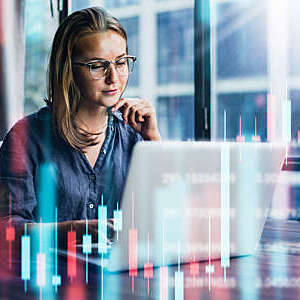 Young woman working at modern office.Technical price graph and indicator, red and green candlestick chart and stock trading computer screen background. Double exposure. Trader analyzing data