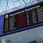 Airport international departures board with all flights marked as cancelled in red letters.